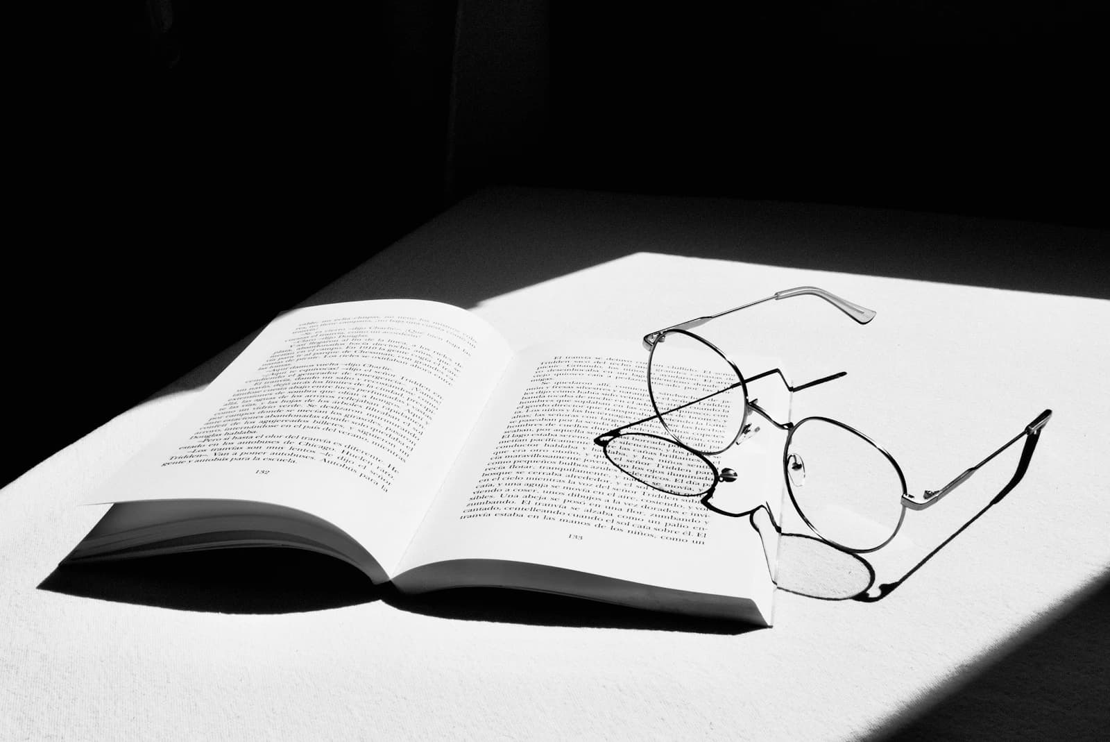 Eyeglasses with progressive lenses resting on an open book, reading zone in focus